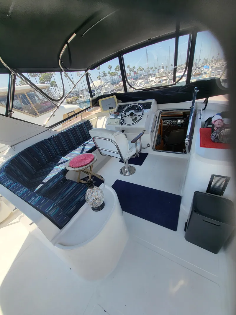 Slide: The Image of 1997 McKinna 48' Pilot House interior with helm, seating, and marina view. - 18