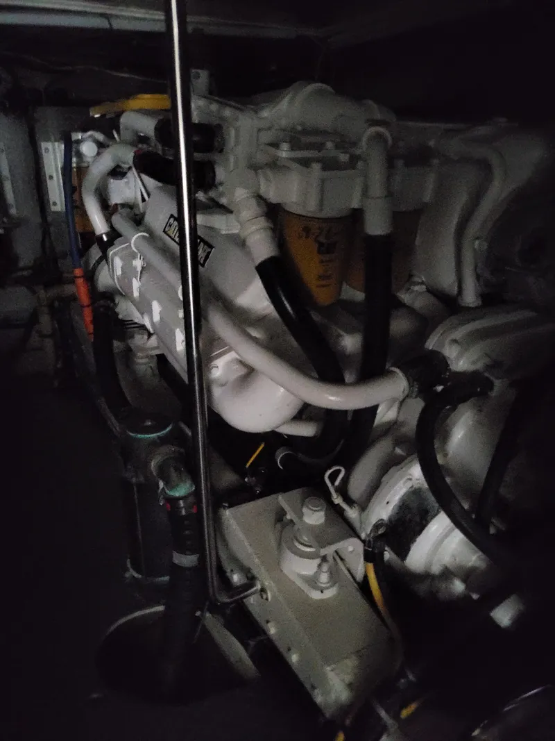 Slide: The Image of Engine room of a 1997 McKinna 48' Pilot House yacht, showcasing mechanical components. - 24