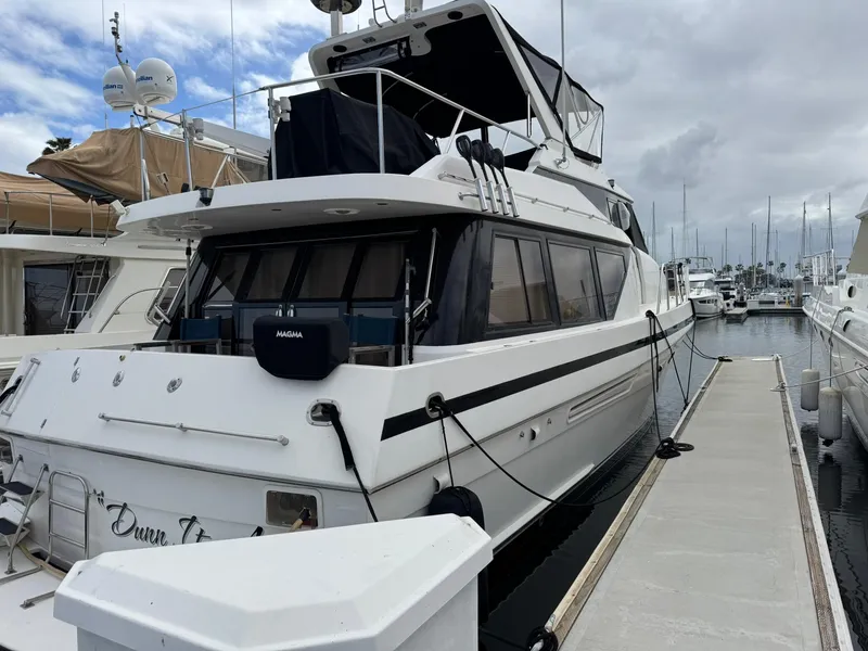 Slide: The Image of 1997 McKinna 48' Pilot House yacht docked at marina under cloudy sky. - 25