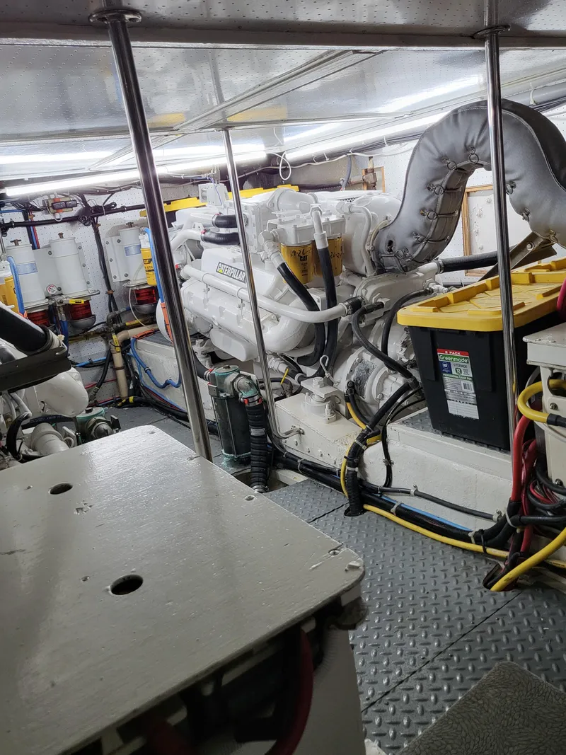 Slide: The Image of Engine room of a 1997 McKinna 48' Pilot House yacht, showcasing machinery and wiring. - 26