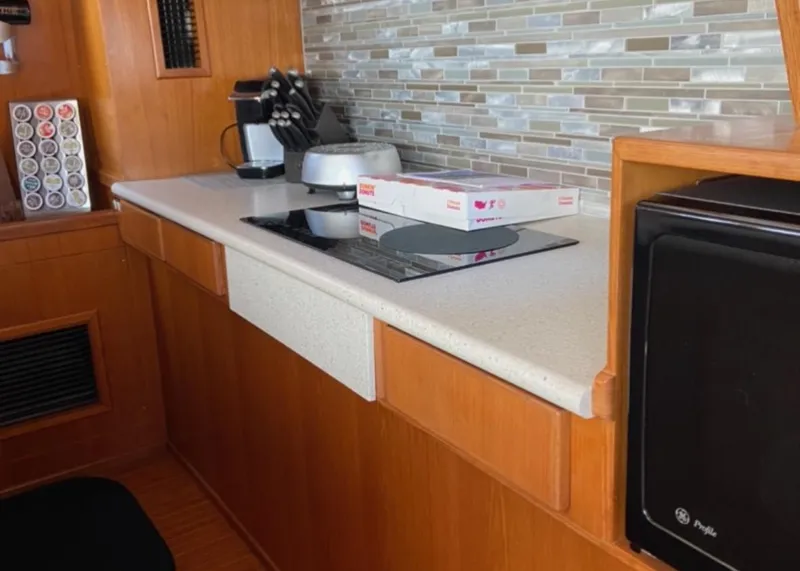 Slide: The Image of 1997 McKinna 48' Pilot House kitchen with modern appliances and sleek countertop design. - 4