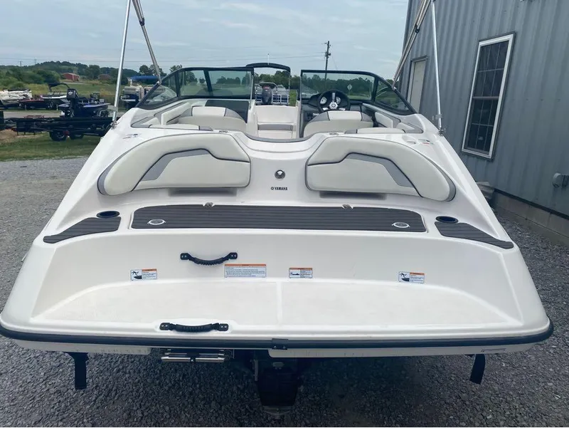 Slide: The Image of 2017 Yamaha Boats SX190, rear view, white exterior, parked near a building. - 8