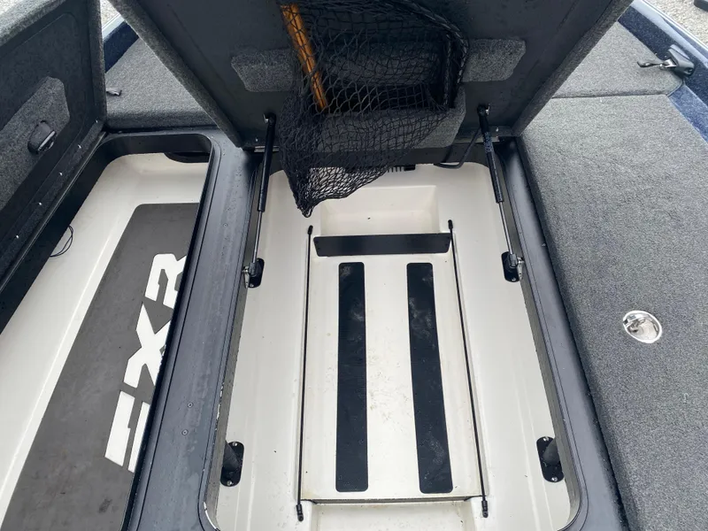 Slide: The Image of 2020 Skeeter FXR20 Limited boat storage compartment with net and FXR branding. - 15