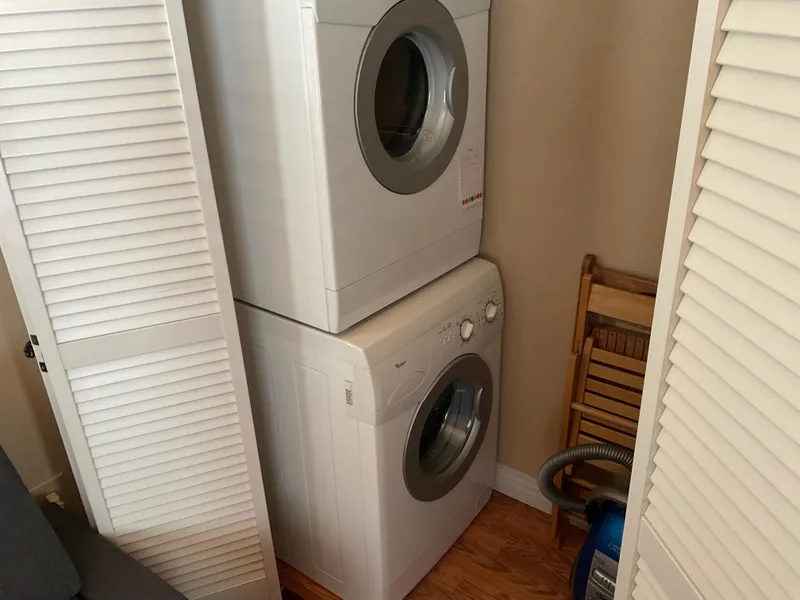 Slide: The Image of Stacked washer and dryer in a compact laundry space with wooden flooring. - 10