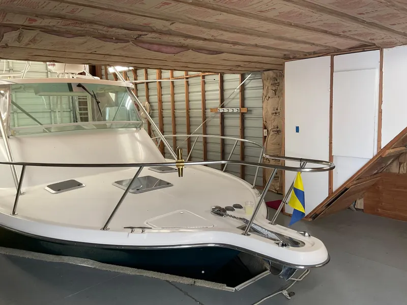 Slide: The Image of Custom 1987 boathouse with docked boat, featuring a Swedish flag and unfinished interior. - 11