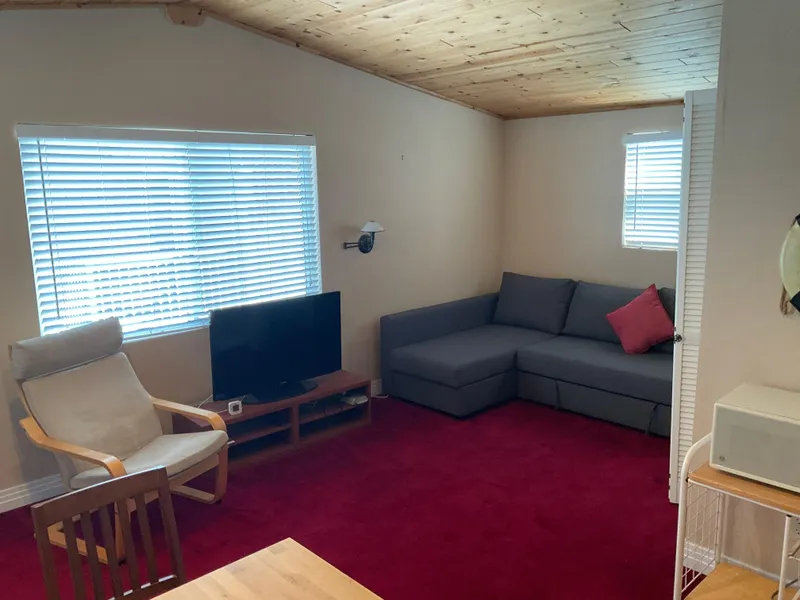 Slide: The Image of Cozy living room in a 1987 custom boathouse with red carpet, gray sofa, and wooden ceiling. - 4