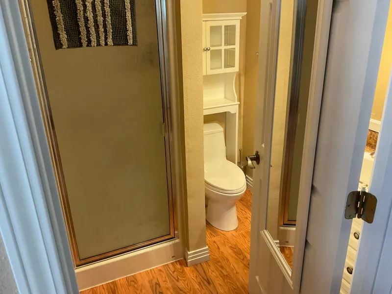 Slide: The Image of Compact bathroom with shower, toilet, and wooden flooring in a 1987 custom boathouse. - 9