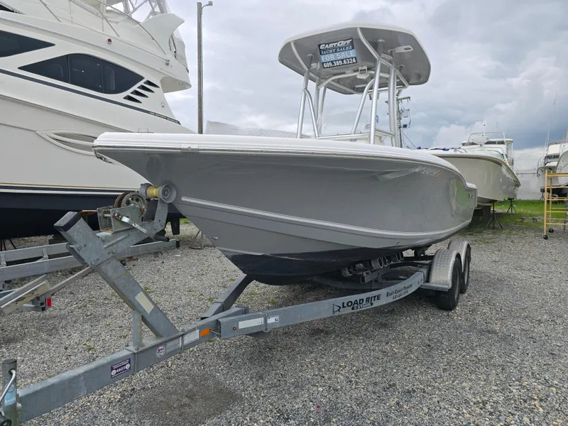 Slide: The Image of 2016 Tidewater 210 LXF boat on trailer, parked in a marina with overcast skies. - 0