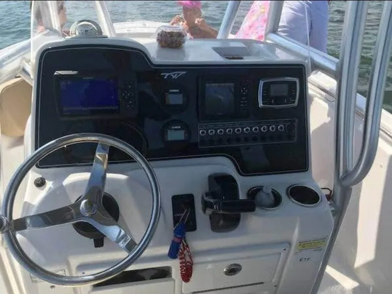 Slide: The Image of 2016 Tidewater 210 LXF boat dashboard with steering wheel and navigation controls. - 2