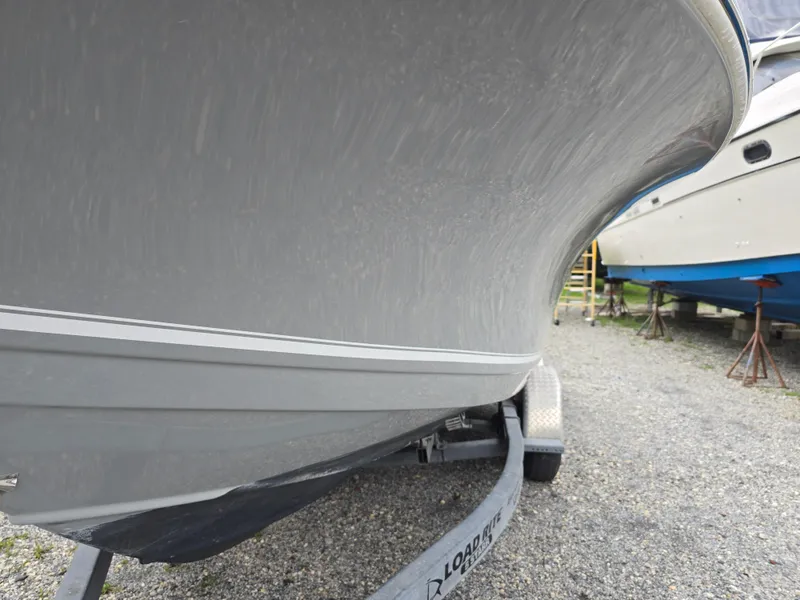 Slide: The Image of 2016 Tidewater 210 LXF boat on trailer, side view, parked on gravel. - 3
