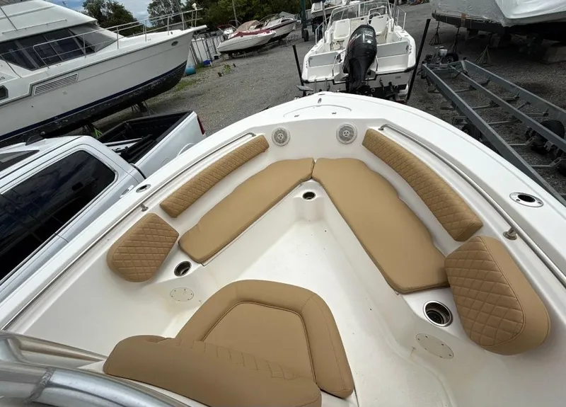 Slide: The Image of 2016 Tidewater 210 LXF boat with tan cushioned seating, docked in a marina. - 7