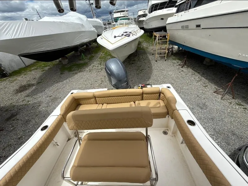 Slide: The Image of 2016 Tidewater 210 LXF boat with tan seating, parked among other boats. - 8