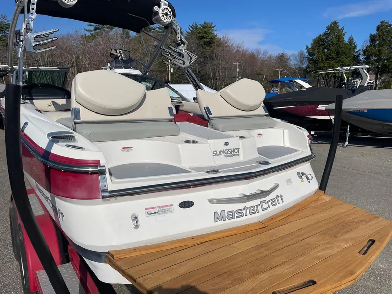Slide: The Image of 2010 MasterCraft X-25 boat with teak swim platform, parked outdoors. - 1