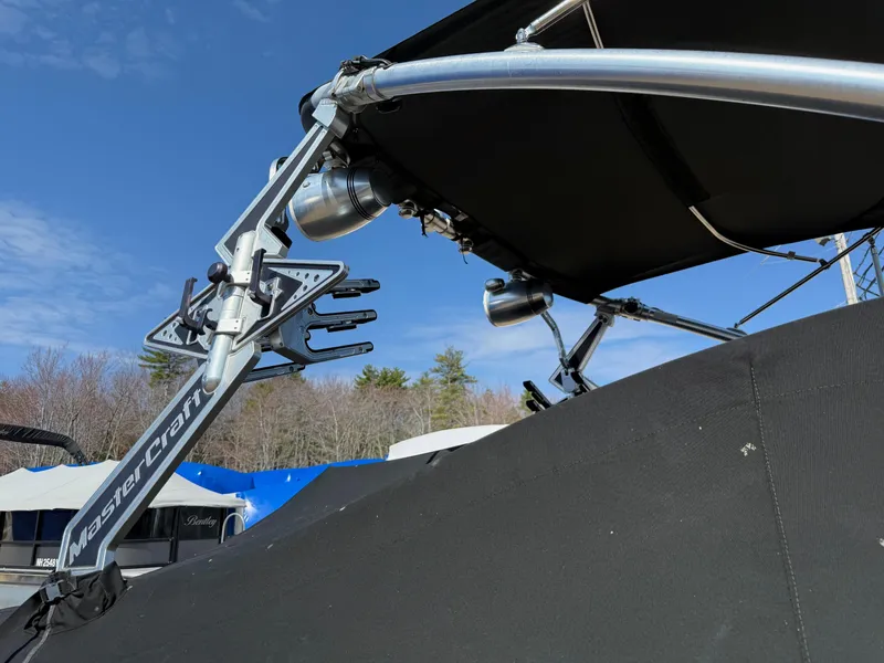 Slide: The Image of 2010 MasterCraft X-25 boat with wakeboard rack and canopy under clear blue sky. - 10