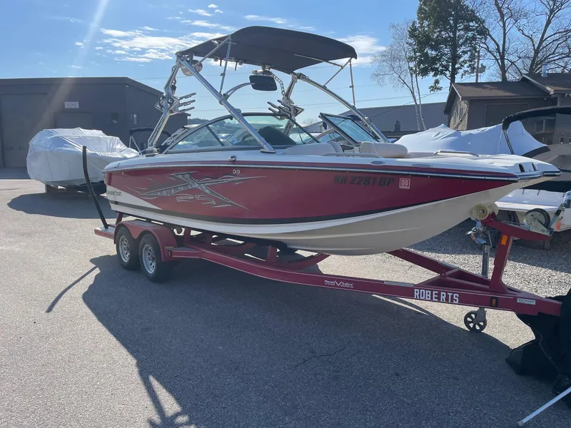 Slide: The Image of 2010 MasterCraft X-25 boat on trailer, red and white, parked outdoors. - 8