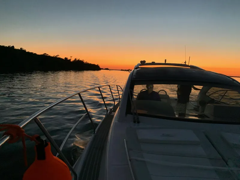 Slide: The Image of Evolve 360HT yacht cruising at sunset, 2022 model, serene water and vibrant sky. - 11