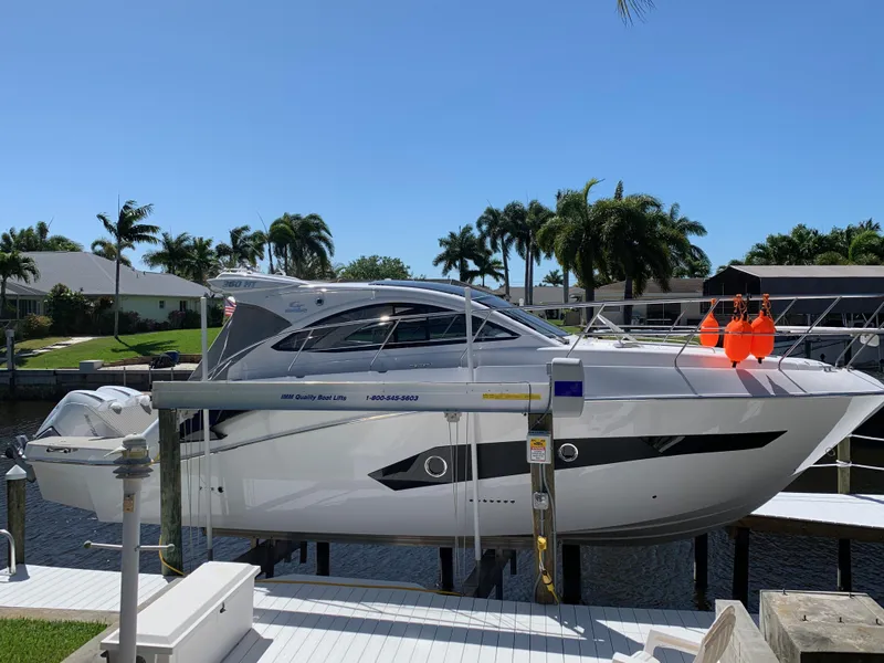Slide: The Image of 2022 Evolve 360HT yacht docked, surrounded by palm trees and waterfront homes. - 24