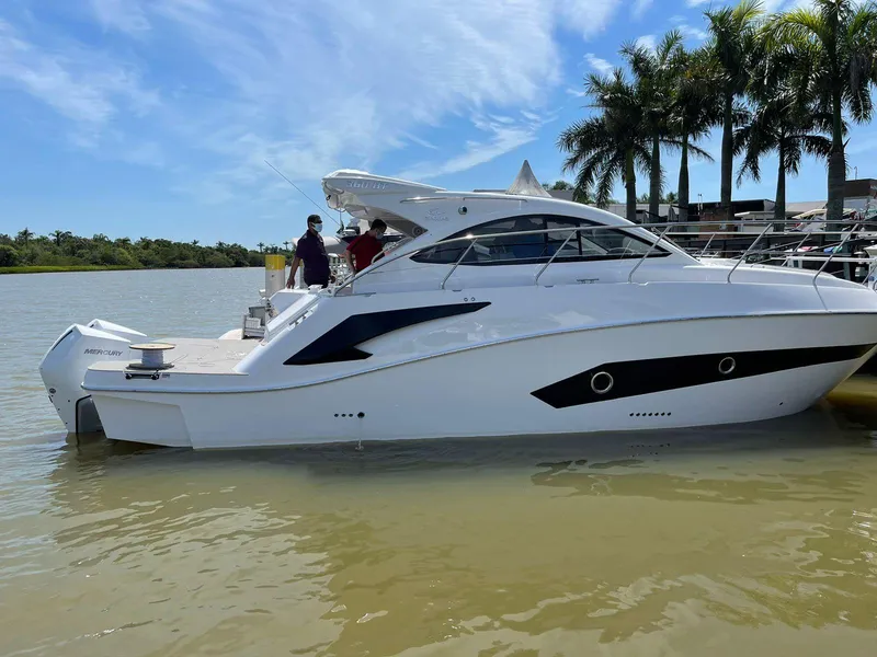 Slide: The Image of 2022 Evolve 360HT yacht docked by palm trees on a sunny day. - 29