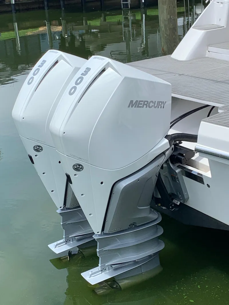 Slide: The Image of Twin Mercury outboard motors on a 2022 Evolve 360HT boat, docked in calm water. - 4