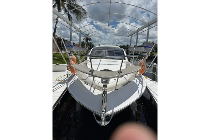 Slide: The Image of 2022 Evolve 360HT yacht docked under a canopy with palm trees in the background. - 53