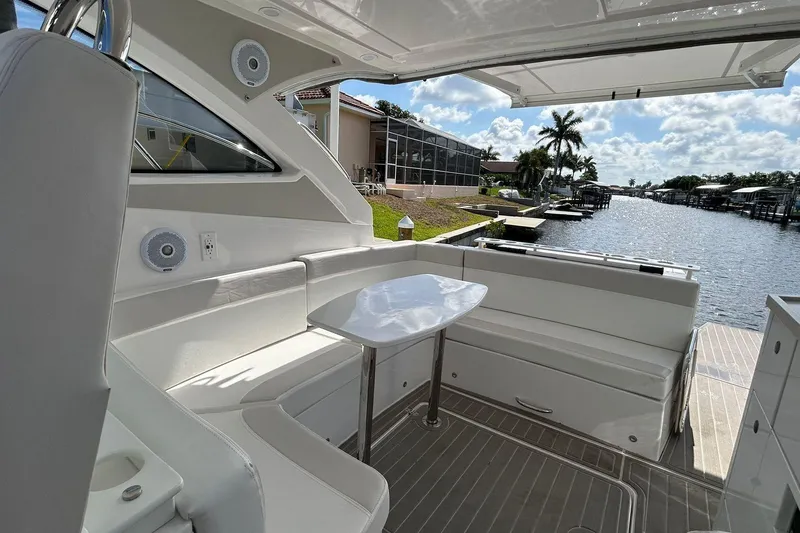Slide: The Image of Luxurious 2021 Evolve 360HT yacht interior with seating and table, overlooking a scenic waterfront. - 56