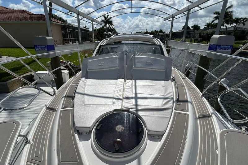 Slide: The Image of 2021 Evolve 360HT yacht with sun loungers, docked in a scenic canal setting. - 65