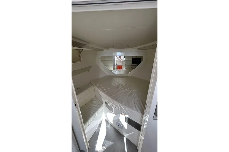 Slide: The Image of 2021 Evolve 360HT boat cabin interior with bed and storage shelves. - 76