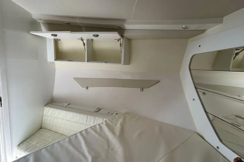 Slide: The Image of Interior of 2021 Evolve 360HT boat with white seating and open storage cabinets. - 79