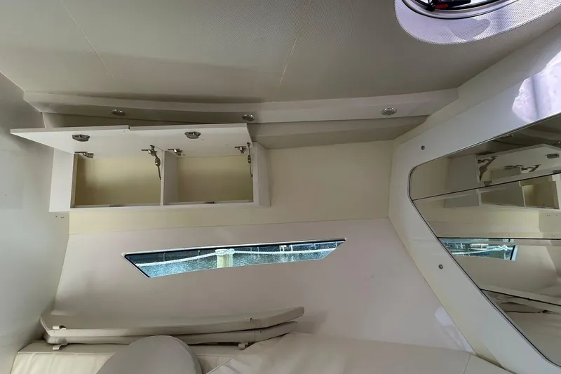 Slide: The Image of Interior of 2021 Evolve 360HT yacht with open storage cabinet and window view. - 81