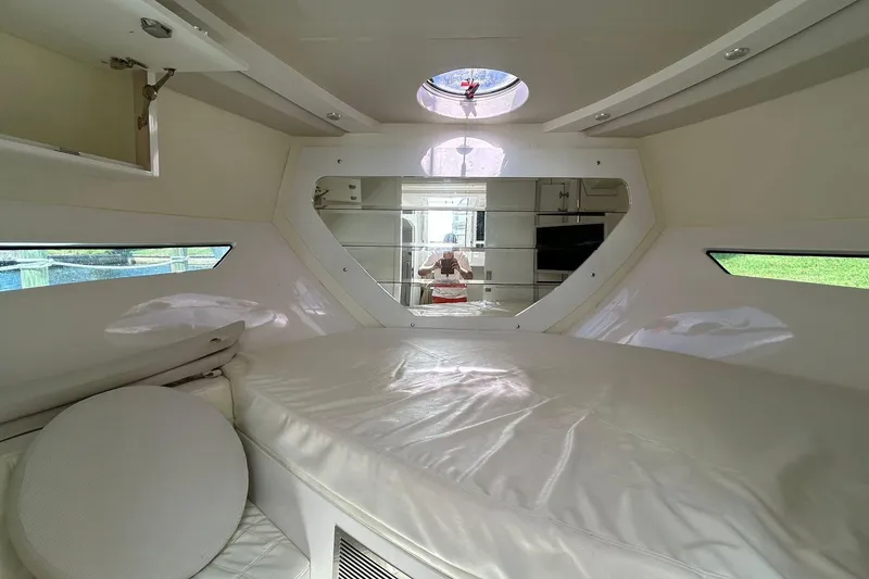 Slide: The Image of Interior cabin of 2021 Evolve 360HT boat with white upholstery and porthole windows. - 82