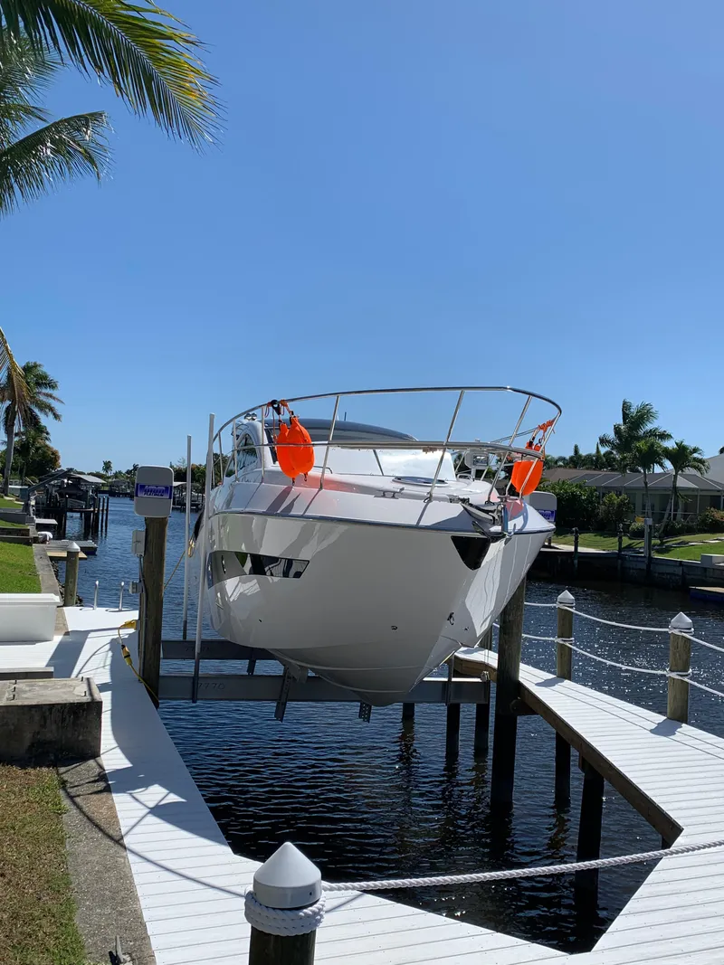 Slide: The Image of 2022 Evolve 360HT yacht docked on a sunny waterfront with palm trees. - 26