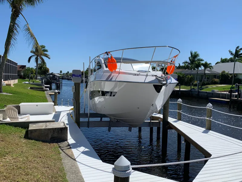 Slide: The Image of Evolve 360HT 2022 yacht docked on a sunny canal with palm trees. - 28