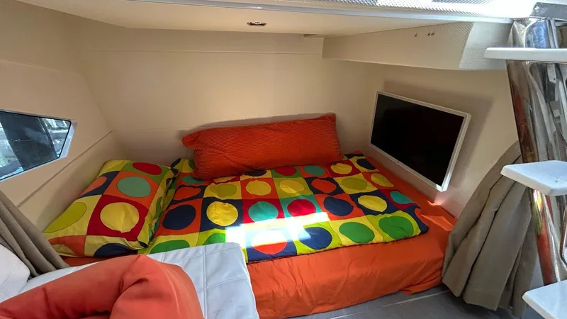 Slide: The Image of Cozy cabin interior of 2022 Evolve 360HT with colorful bedding and wall-mounted TV. - 35