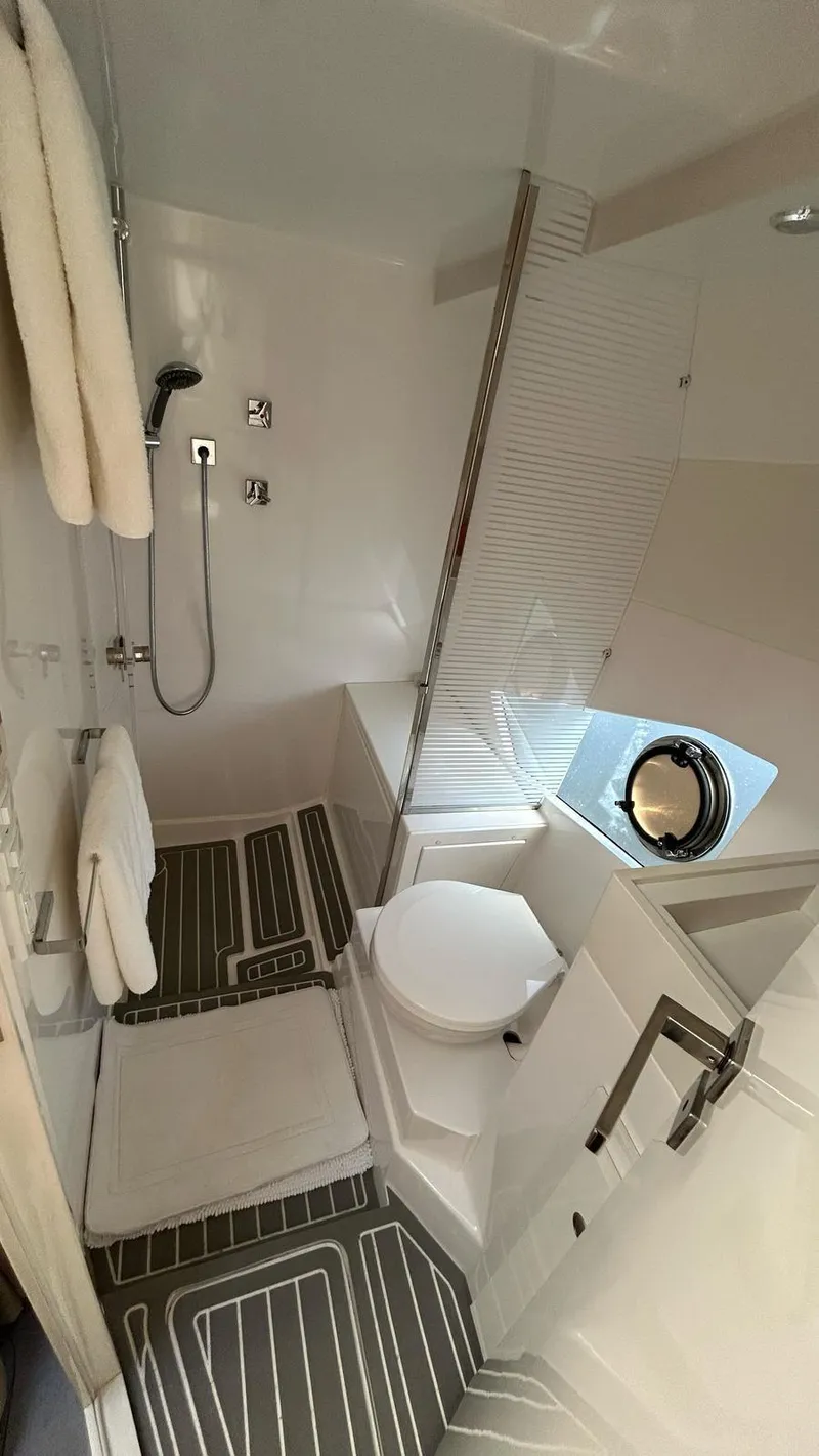 Slide: The Image of Modern bathroom in 2022 Evolve 360HT yacht, featuring shower, toilet, and porthole window. - 40