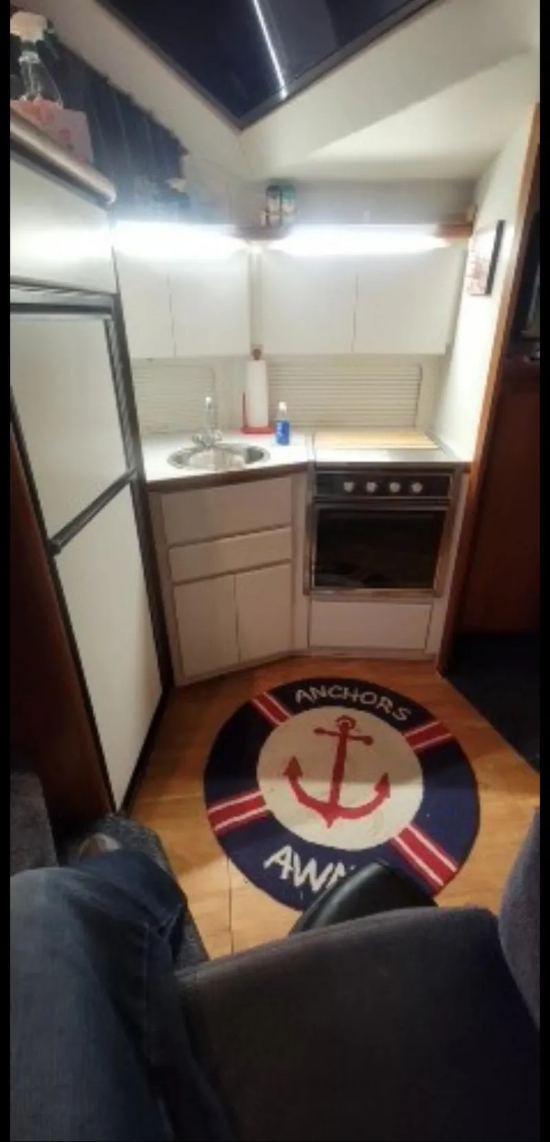 Slide: The Image of Compact kitchen in 1994 Carver 390CPMY boat with nautical-themed rug. - 9