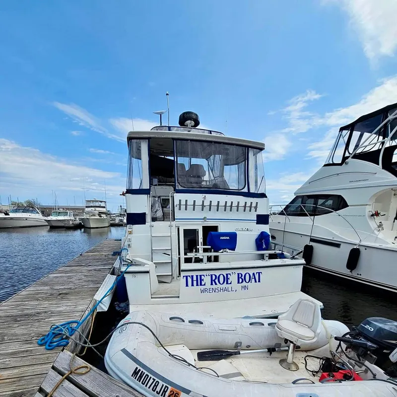 Slide: The Image of 1994 Carver 390CPMY yacht docked, named "The Roe Boat," with inflatable dinghy attached. - 5