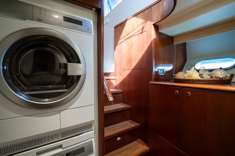 Slide: The Image of Laundry area in 2004 Cheoy Lee 84 Bravo Flybridge yacht with wooden cabinetry and stairs. - 19