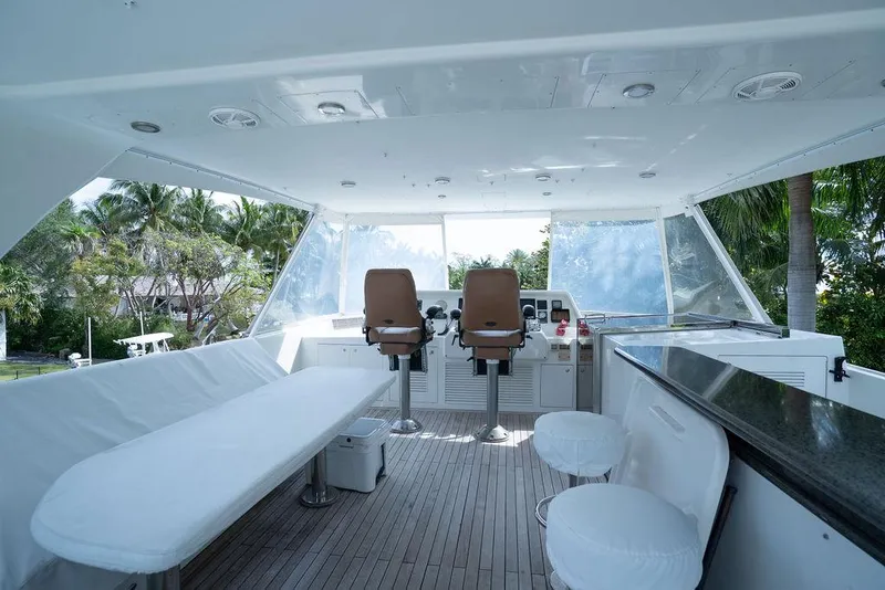 Slide: The Image of Flybridge of 2004 Cheoy Lee 84 Bravo yacht with seating and helm, surrounded by tropical scenery. - 39
