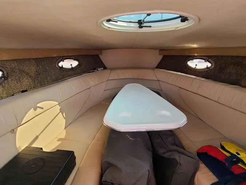 Slide: The Image of Interior of 2003 Cobalt 263 boat with beige seating and oval windows. - 10