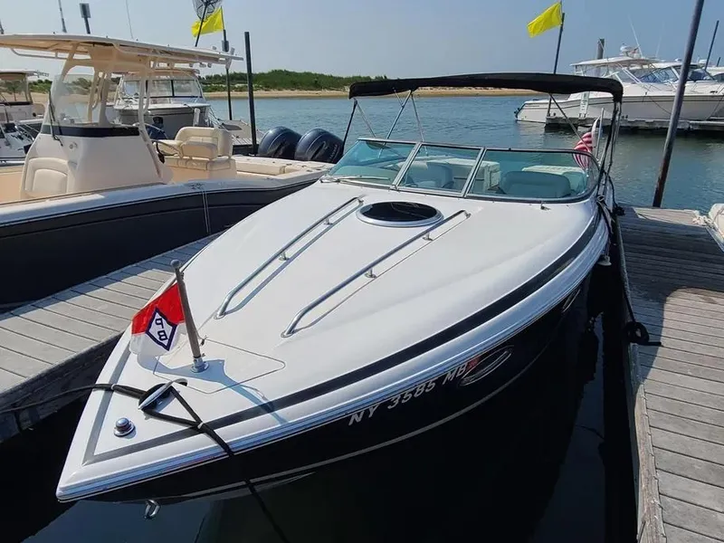 Slide: The Image of 2003 Cobalt 263 boat docked at marina, featuring sleek design and white exterior. - 2