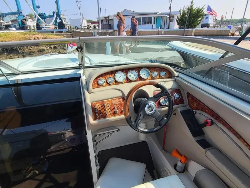 Slide: The Image of Interior of a 2003 Cobalt 263 boat with wood-accented dashboard and steering wheel. - 8