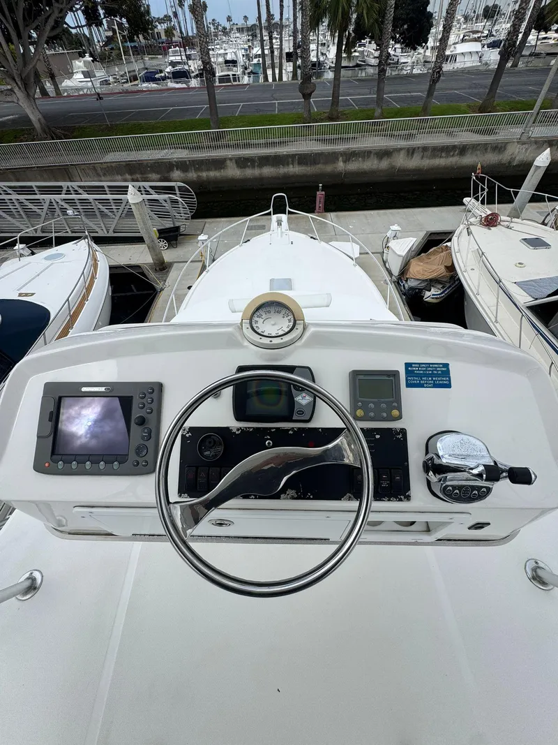 Slide: The Image of 2007 Luhrs 41 Express helm with navigation equipment, docked among other boats. - 16