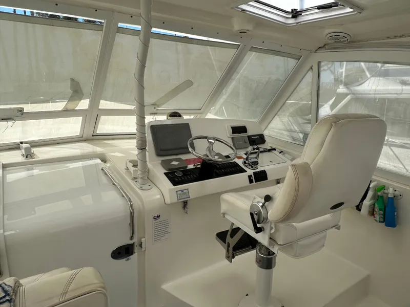 Slide: The Image of 2007 Luhrs 41 Express helm with modern controls and white captain's chair. - 17