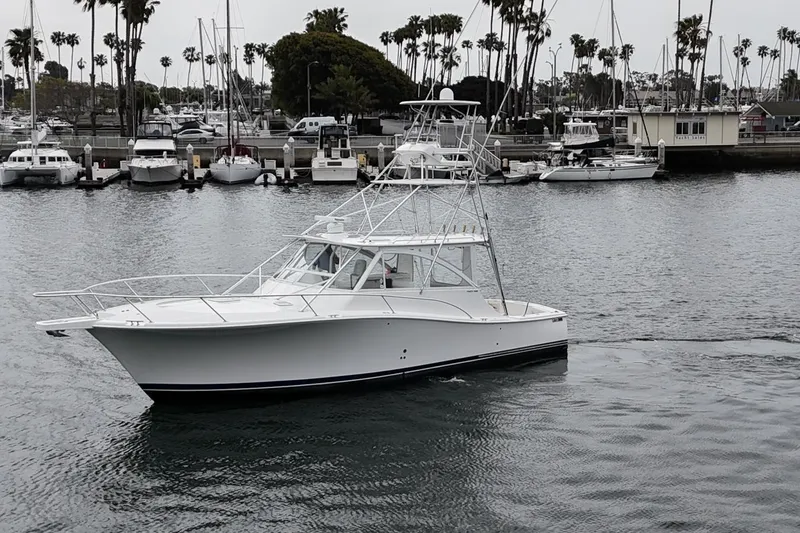 Slide: The Image of 2007 Luhrs 41 Express boat docked in a marina with palm trees in the background. - 3