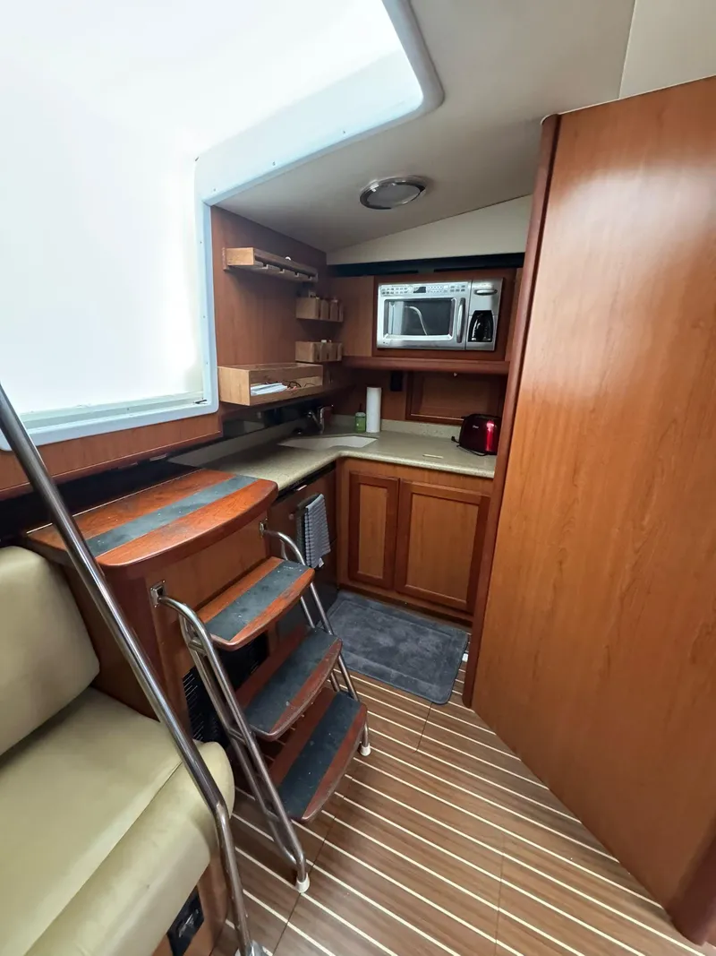 Slide: The Image of 2007 Luhrs 41 Express yacht interior with wooden cabinetry and compact kitchen area. - 36