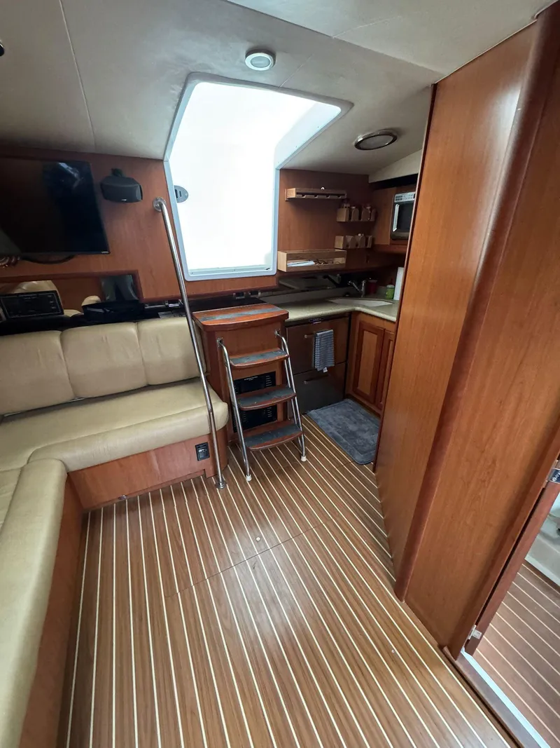 Slide: The Image of 2007 Luhrs 41 Express interior with wood flooring, kitchenette, and seating area. - 37
