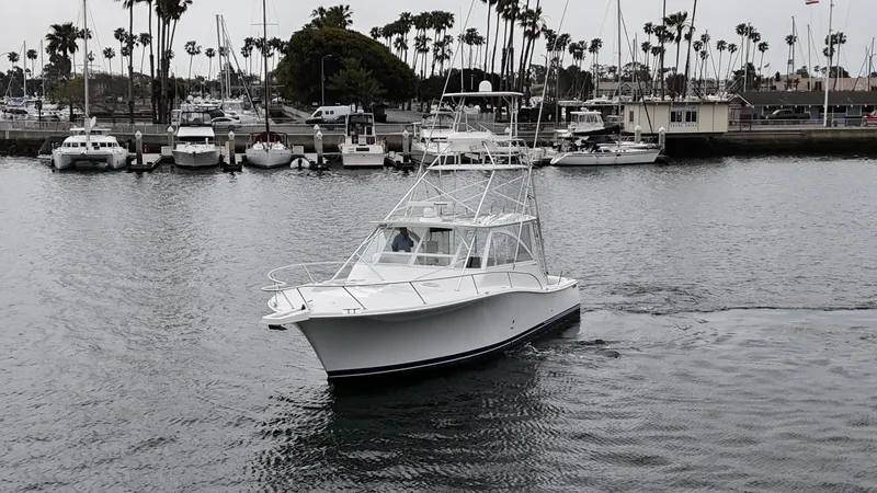 Slide: The Image of 2007 Luhrs 41 Express boat cruising near a marina with palm trees in the background. - 4