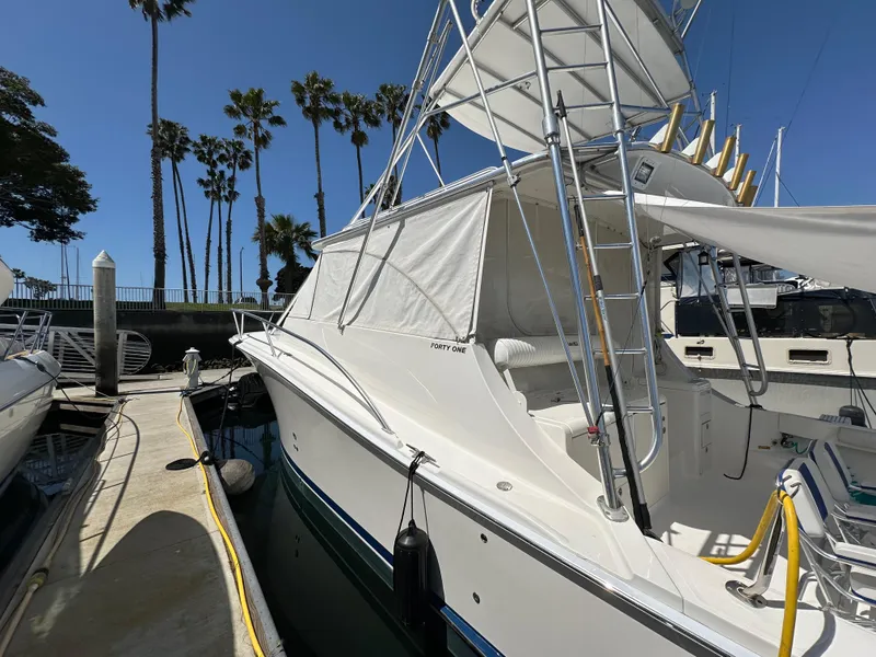 Slide: The Image of 2007 Luhrs 41 Express boat docked, featuring a sleek design and palm trees in the background. - 46