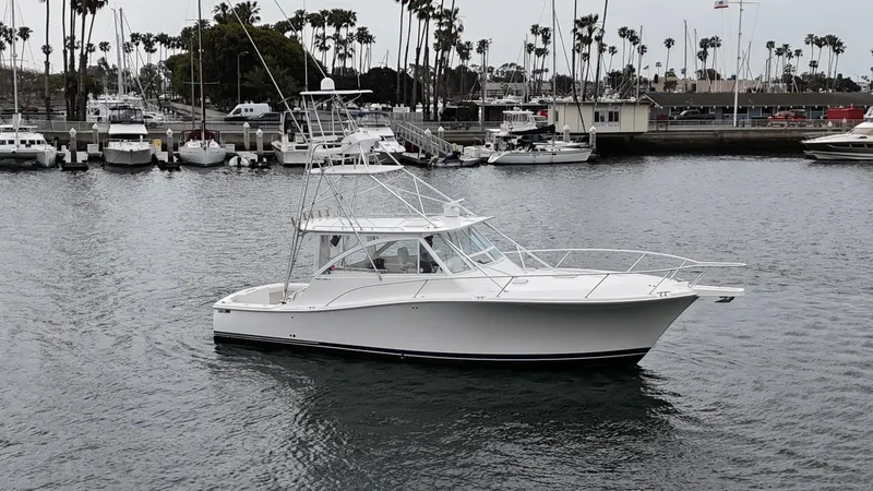 Slide: The Image of 2007 Luhrs 41 Express boat docked in a marina with palm trees in the background. - 6
