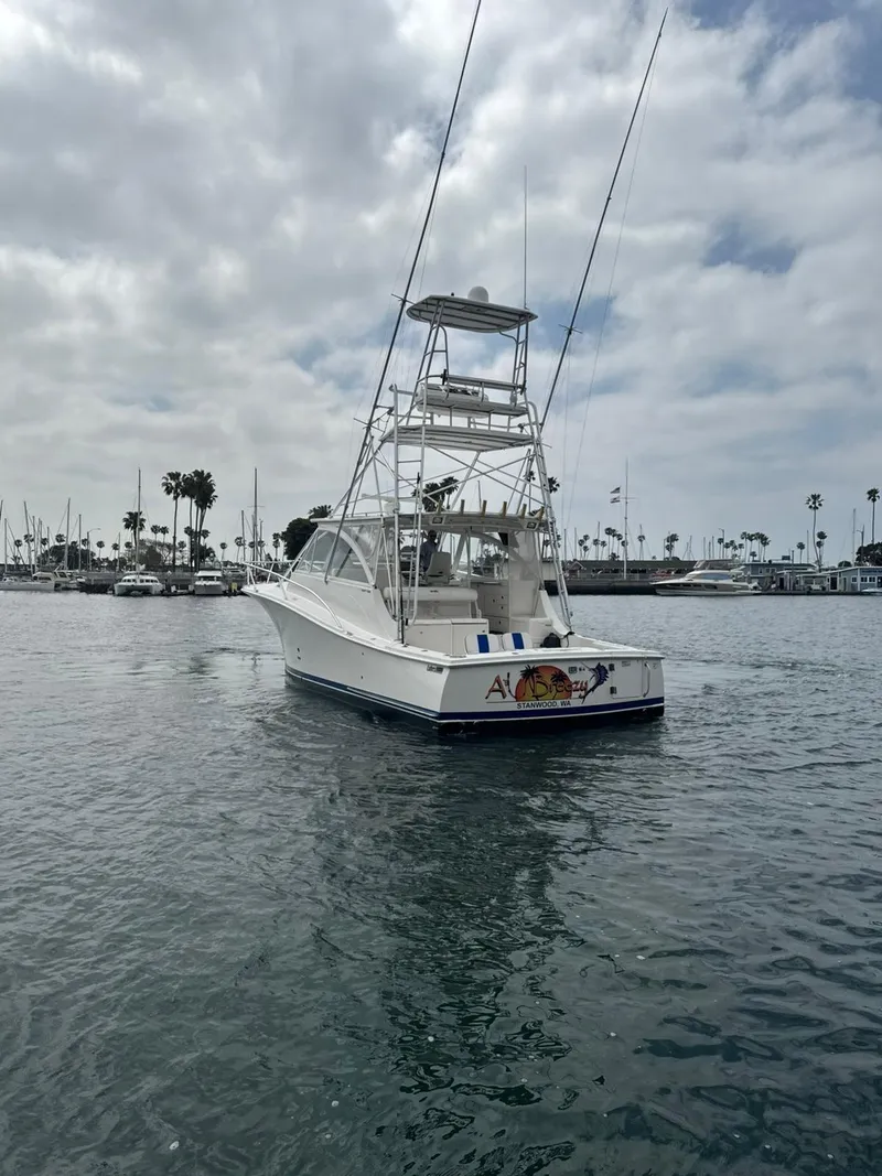 Slide: The Image of 2007 Luhrs 41 Express boat on calm water with marina background. - 8